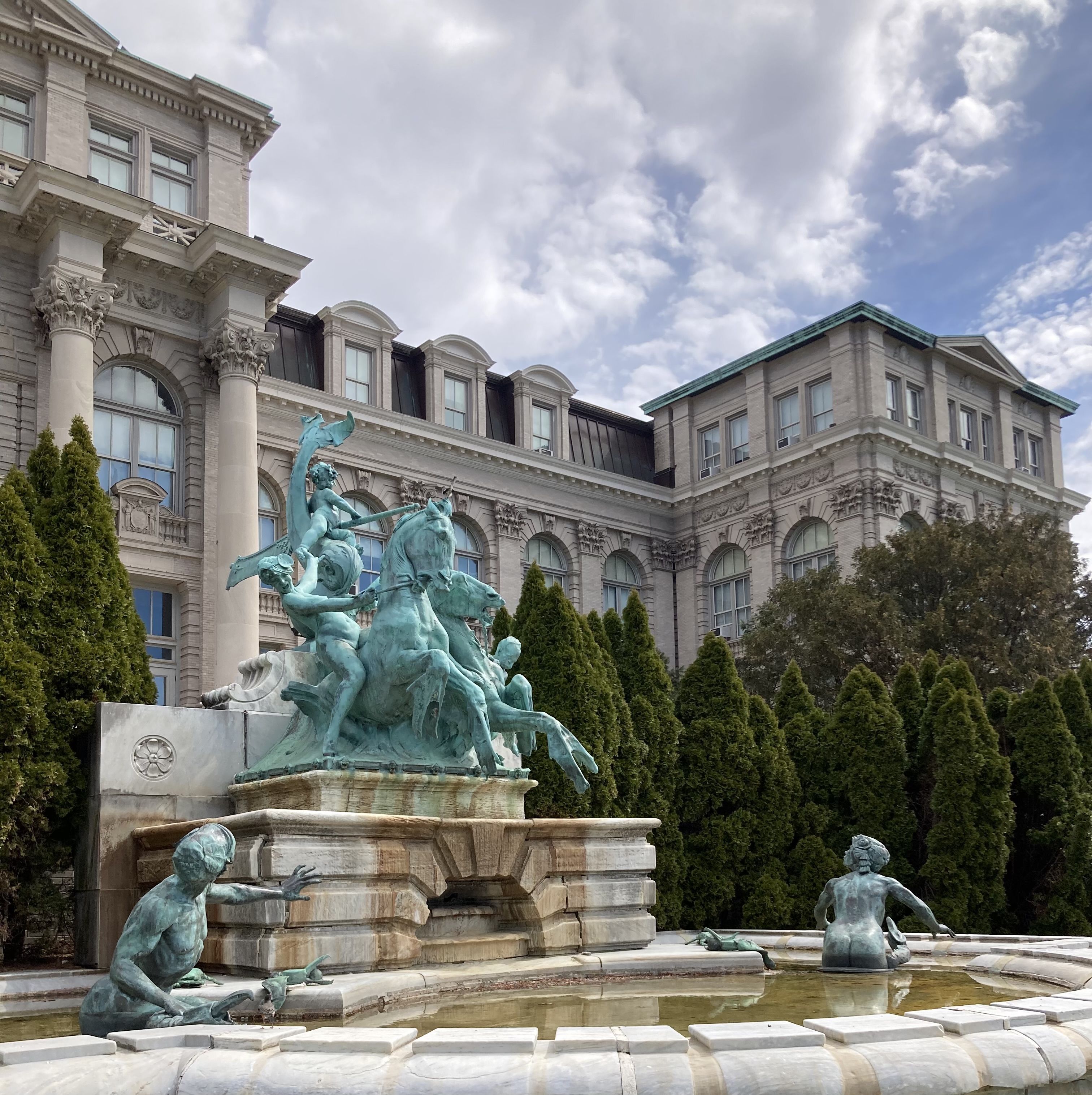 a crowded museum with framed art, busts, and costuming