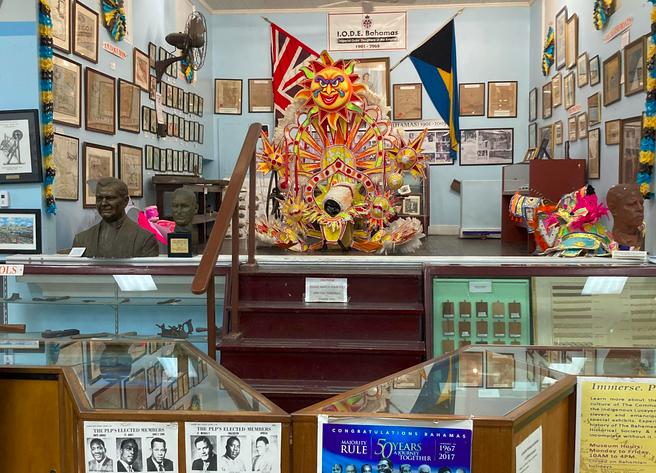 a crowded museum with framed art, busts, and costuming