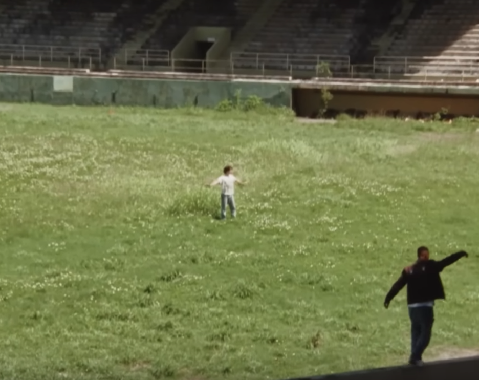 a man in the field of an abandoned stadium
